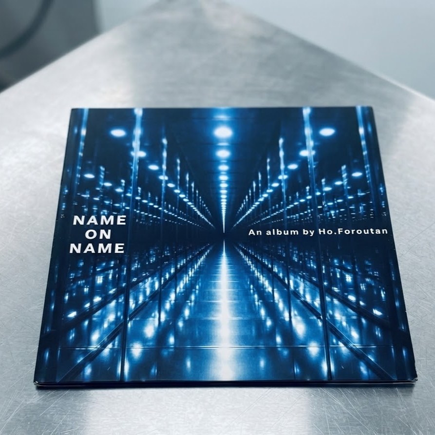 The album sleeve lying on a brushed steel surface